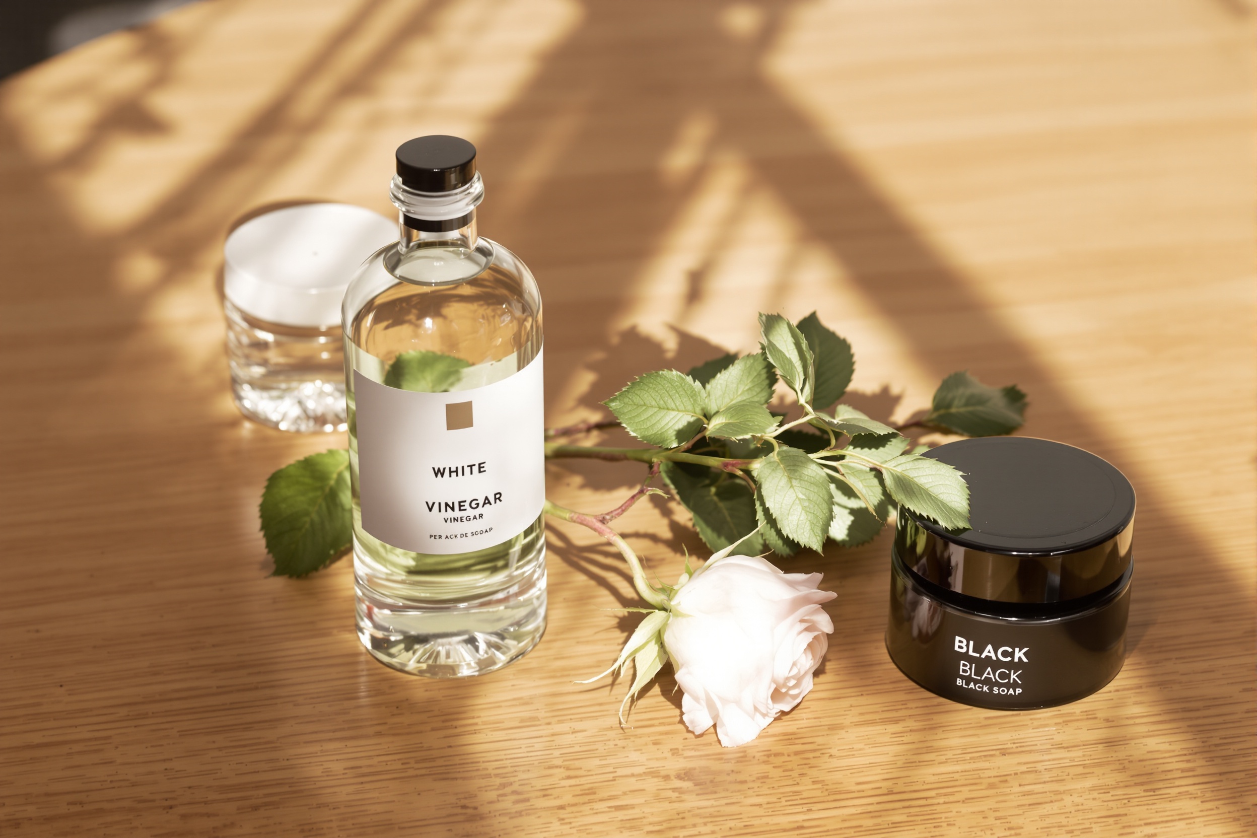 Comparatif : vinaigre blanc contre savon noir sur table de jardin.