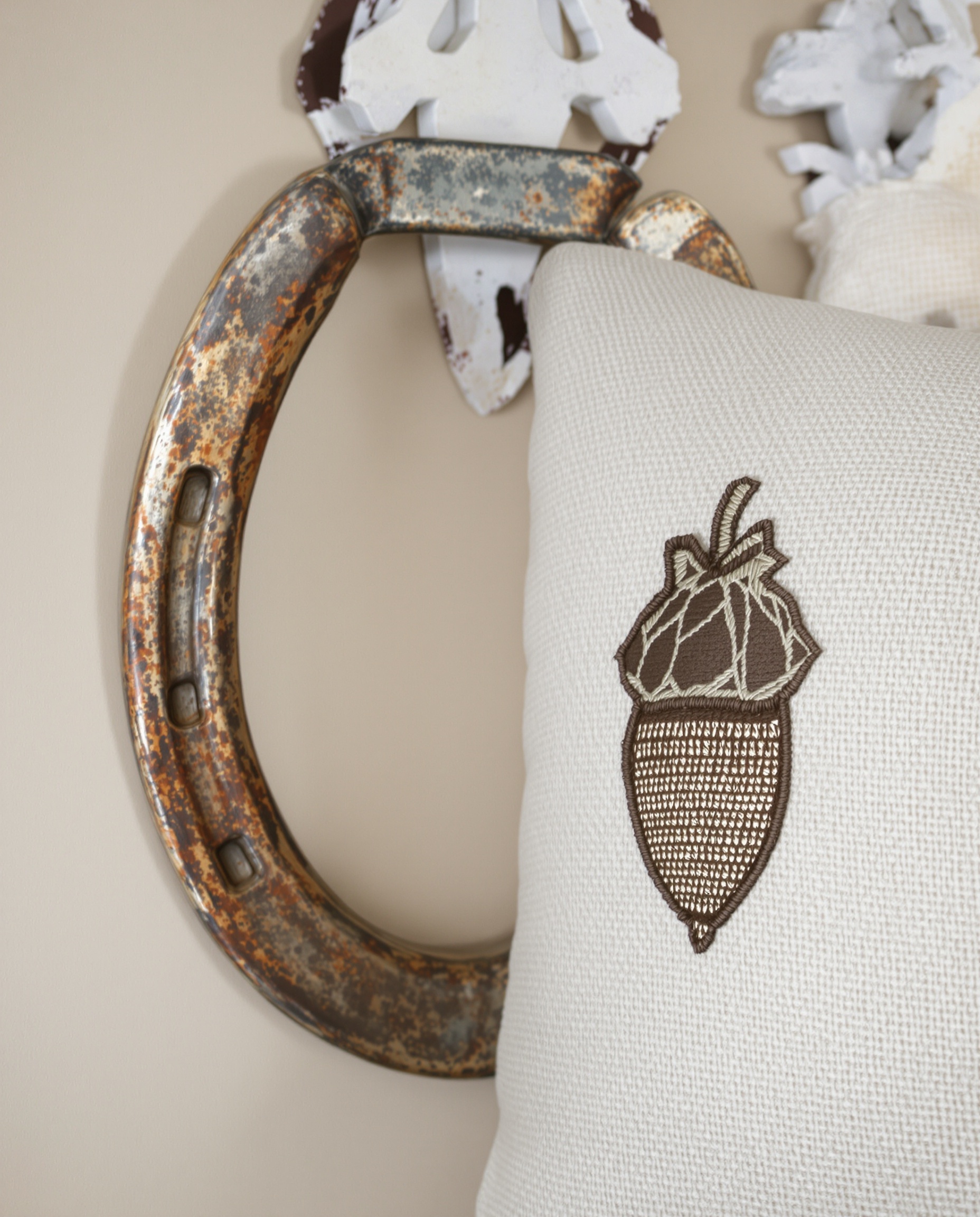 composition murale décoration fer à cheval patiné coussin motif gland stylisé