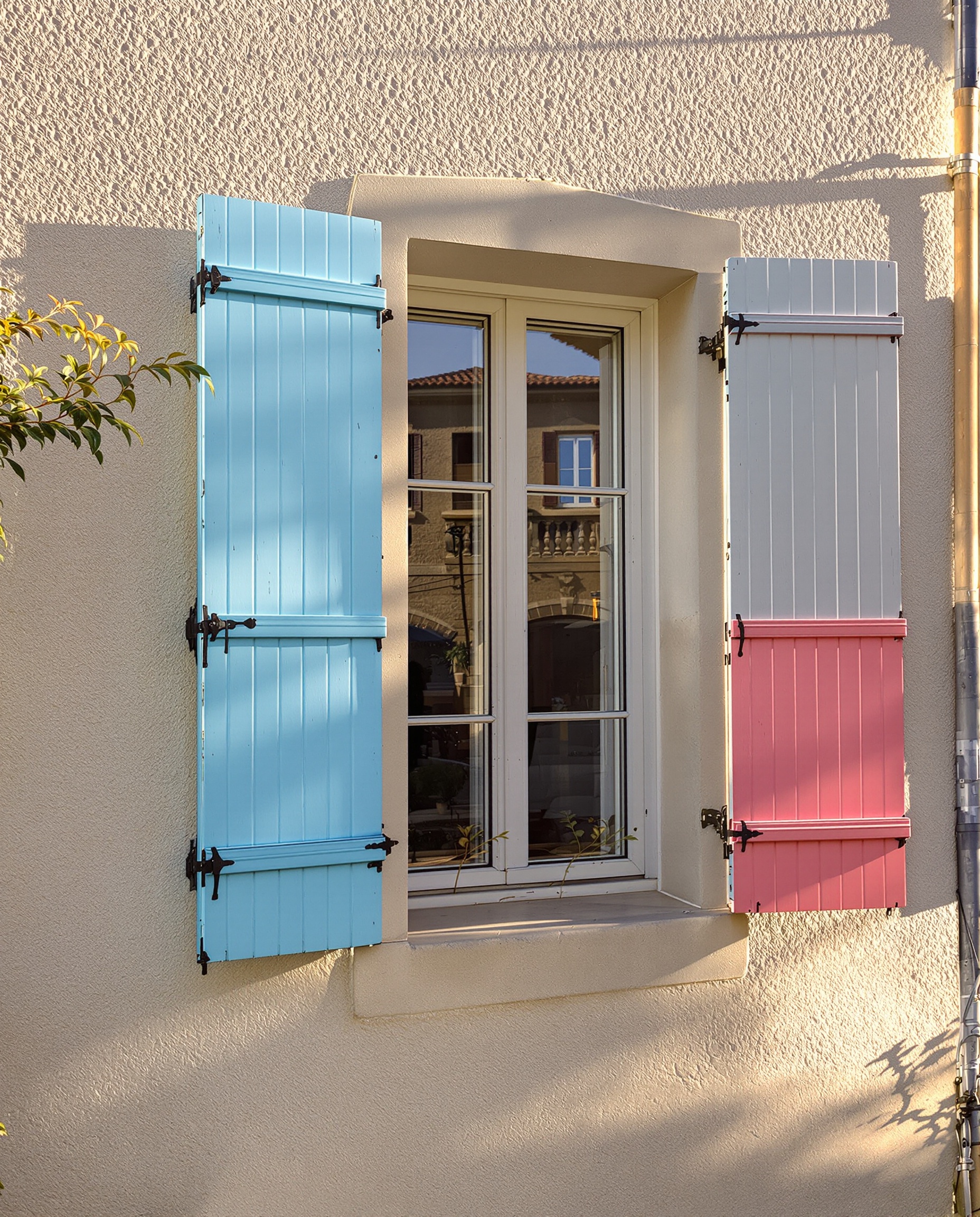 Façade provençale chic avec volets rénovés couleur vive au soleil doré